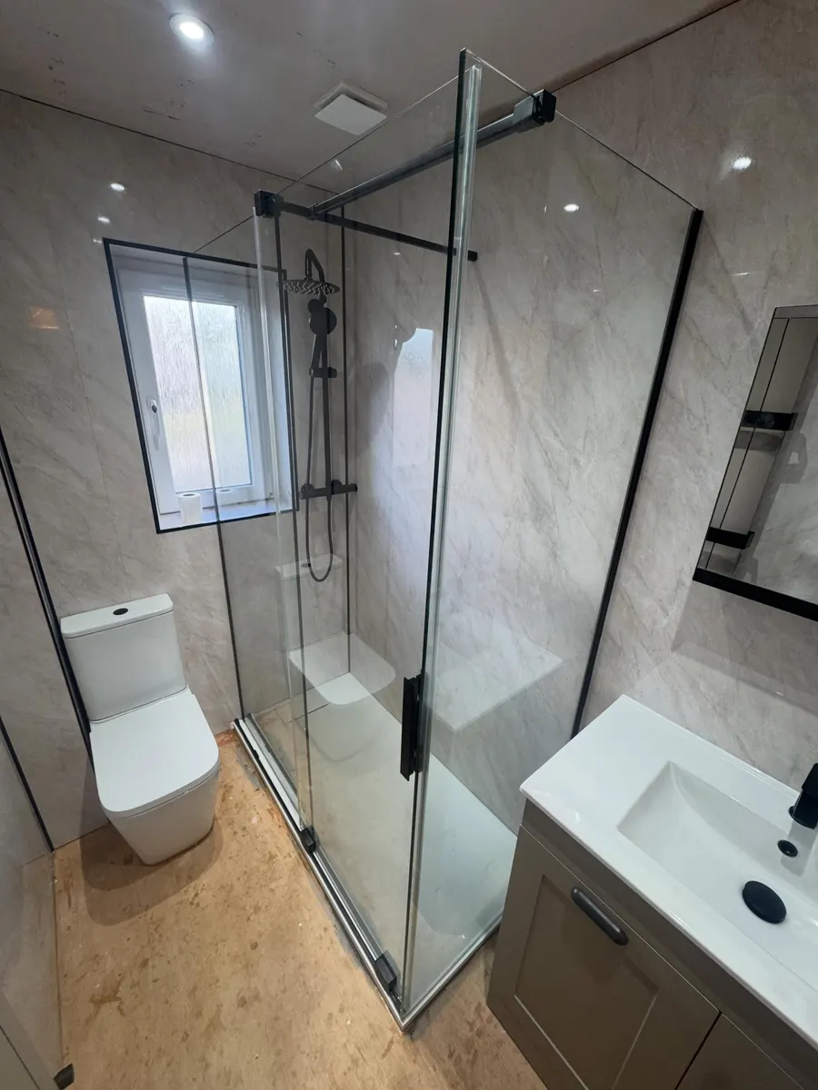 Shower room with a black framed glass enclosure, grey marble-effect walls and vanity basin
