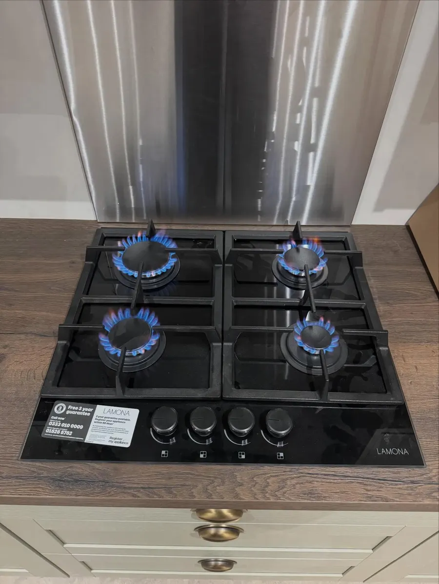 Black glass four-burner gas hob with all burners lit
