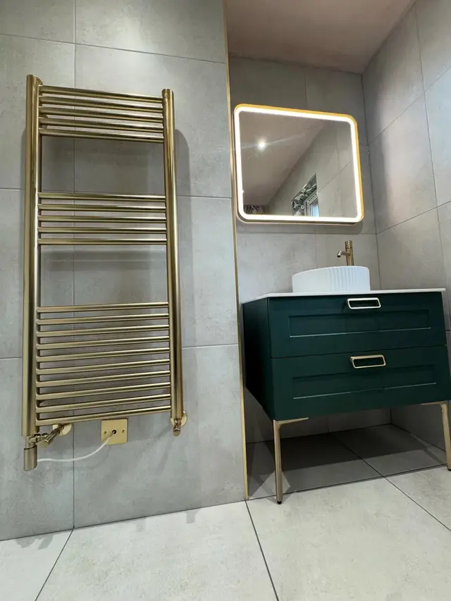 Bathroom with a gold heated towel rail and green vanity unit