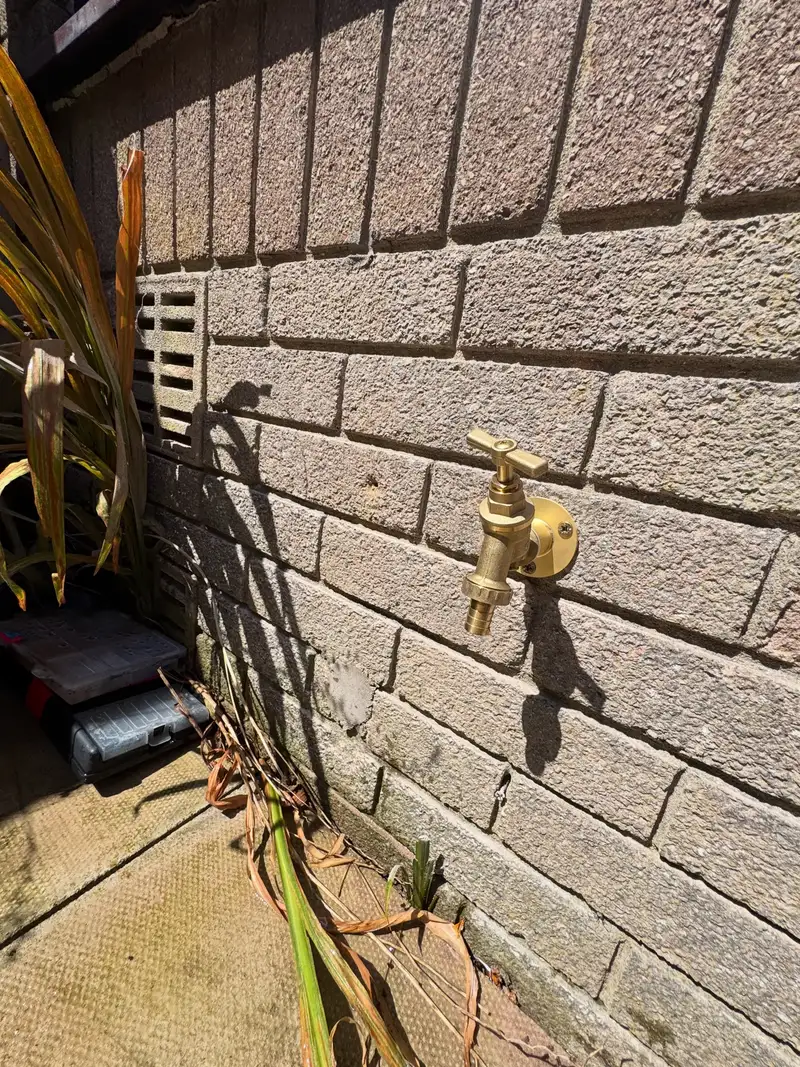 New brass outside tap fitted to a brick wall